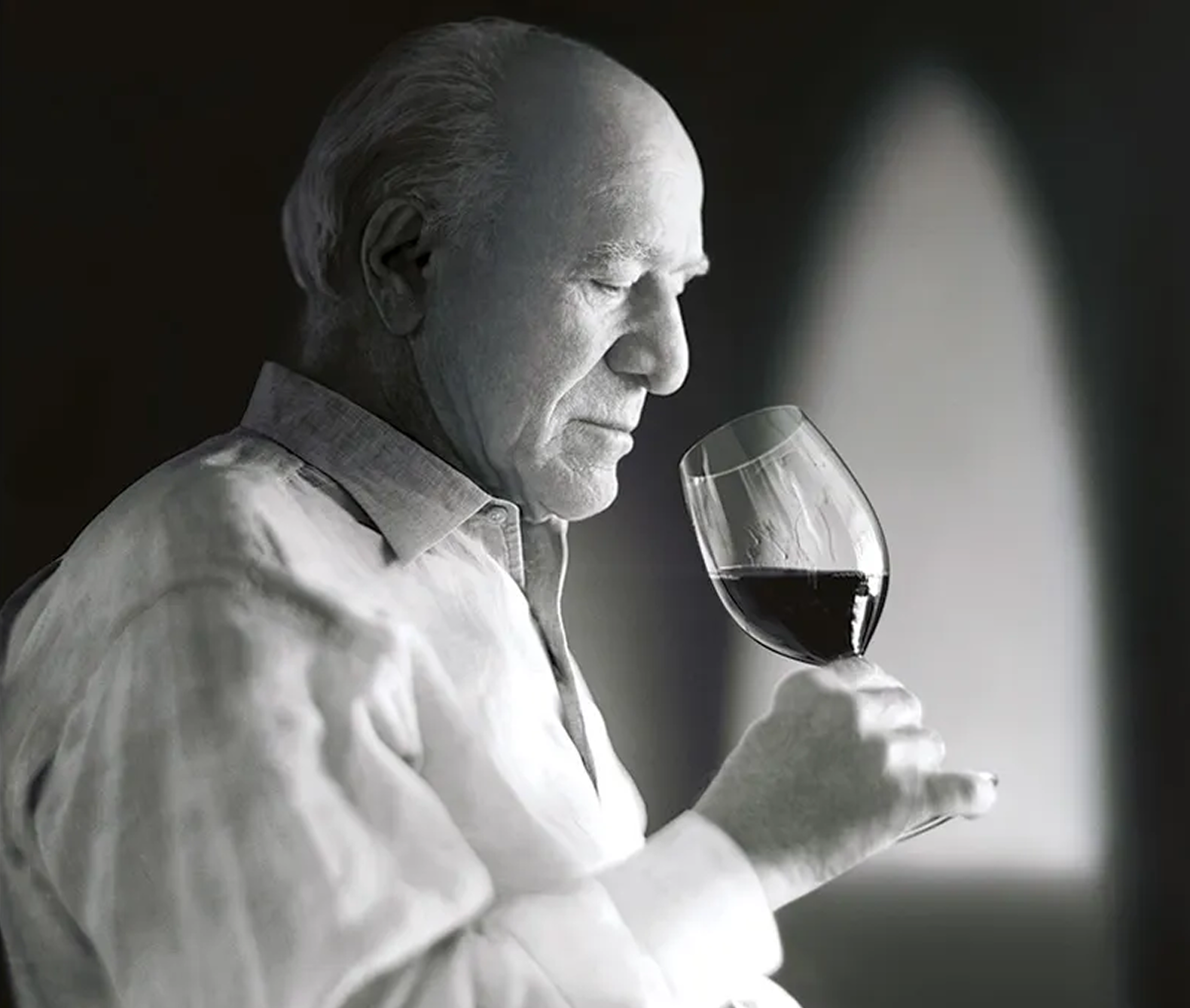Black and white picture of Robert Mondavi about to drink a glass of red wine