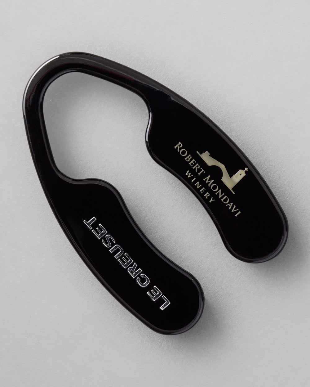 The black Robert Mondavi Winery x Le Creuset Foil Cutter on a gray background