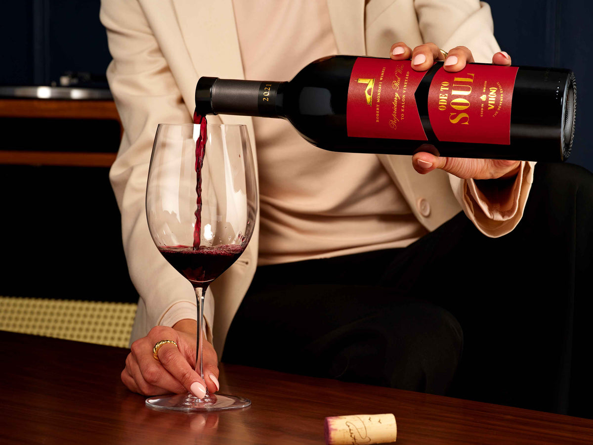 Woman pouring red wine into a glass