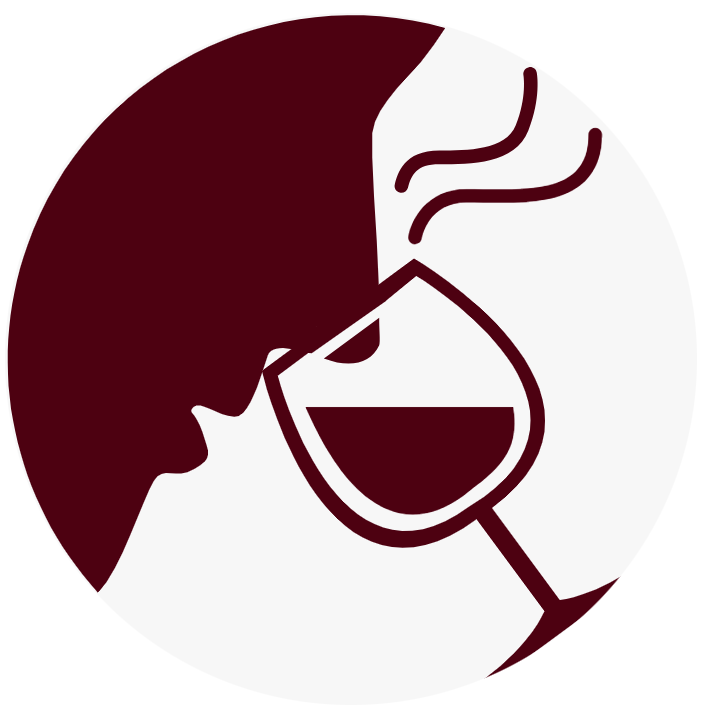 The silhouette of a person sniffing a wine glass.